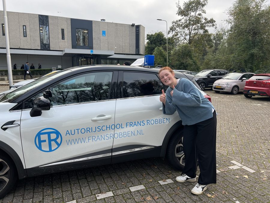 Geslaagde leerling naast de lesauto van Autorijschool Frans Robben